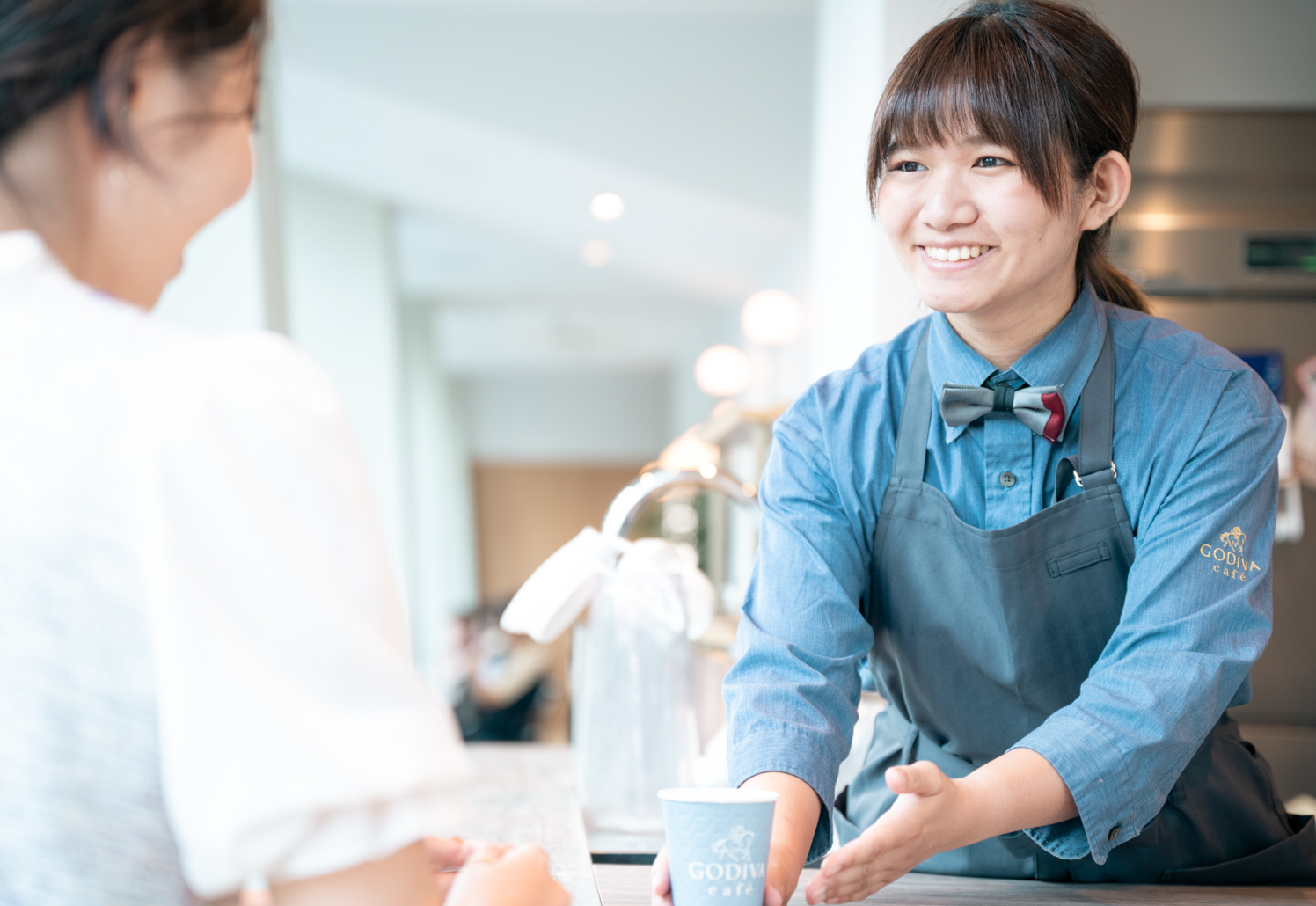 ゴディバカフェで接客を行う女性店員